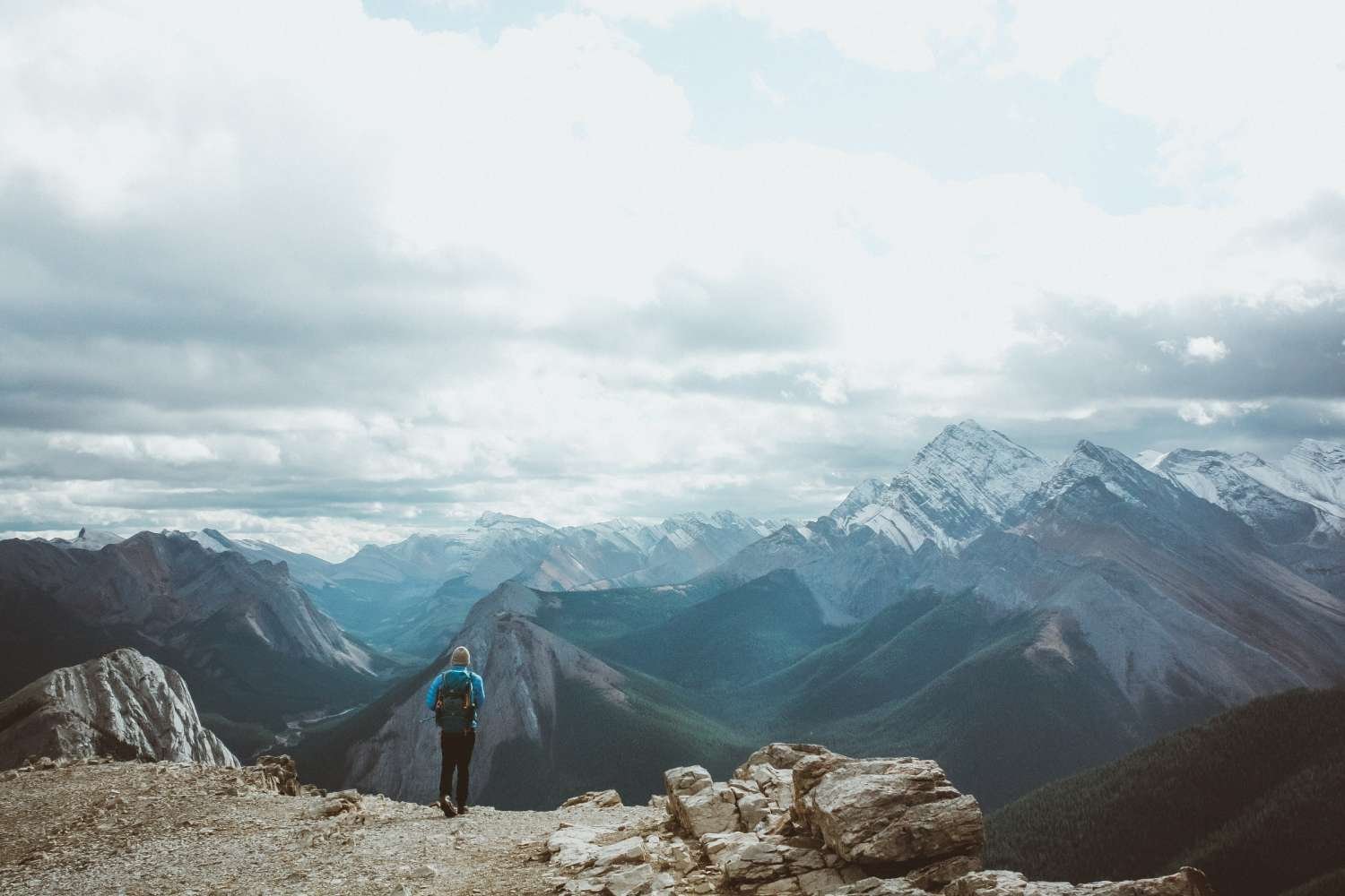 Backpacker overlooking snow capped mountain wilderness